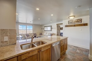 Double sink, dishwasher, and very open kitchen, dining room, living room layout.