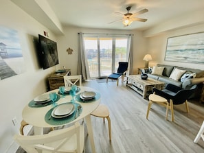 Dining table for four, plus four bar stools at the kitchen counter.
