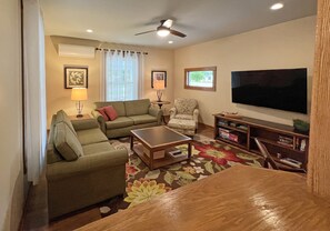 Spacious Living Room with Large Flatscreen TV Opens to Dining Room and Kitchen