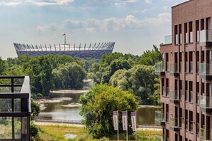A stunning city view showcasing green spaces and modern architecture, captured from a residential balcony.
