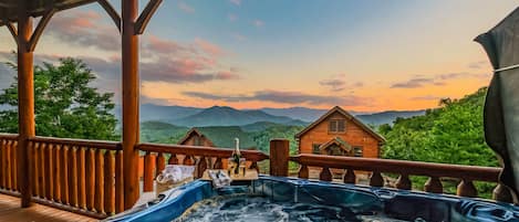 Unwind in the hot tub while admiring the Smoky Mountain view (wine is for staging purposes, not included in stay)