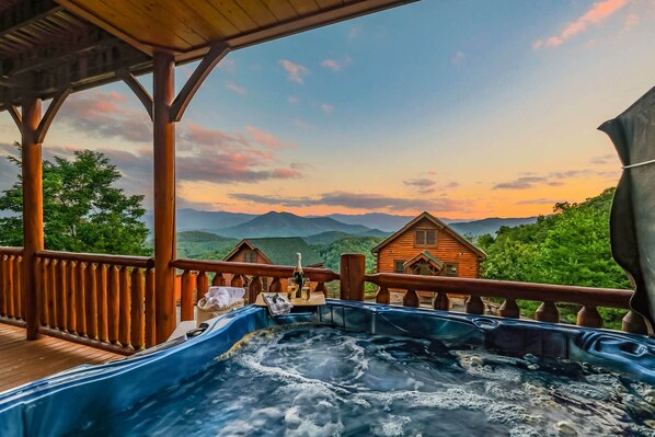 Unwind in the hot tub while admiring the Smoky Mountain view (wine is for staging purposes, not included in stay)