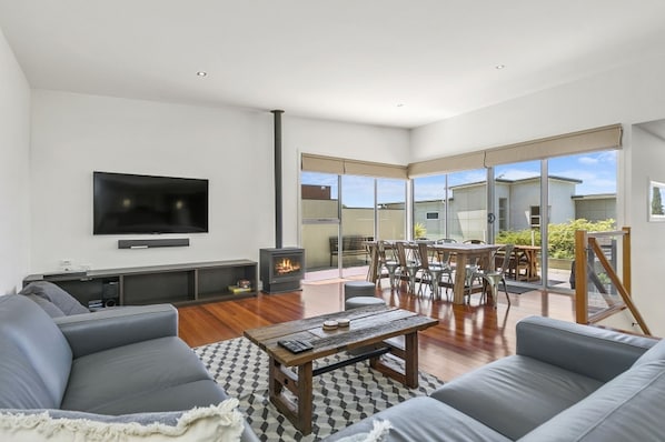 Upstairs living, with corner lounge, bean bags, and stools. 65" Smart TV.