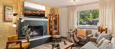 Welcome to The Kaleidoscope! Our cozy living room features a well lit space, 70" Smart TV, and plenty of seating for our guests.