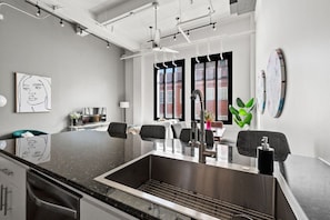 Modern kitchen with a sleek countertop and deep sink — perfect for meal prep or morning coffee.