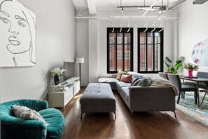 Bright and airy living space with large windows letting in natural light and city views.