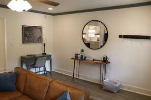 The entryway has a coat rack, basket for shoes and a large mirror.