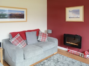 Seating area of dining room with modern wall-mounted fire | Elm Bank, Lochcarron, near Wester Ross