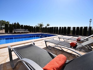 Pool bereich mit Terrasse und Sonnen liegen