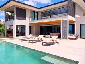 Main terrace with oceanview swimmingpool, sun loungers, lounge area and the main house in the background