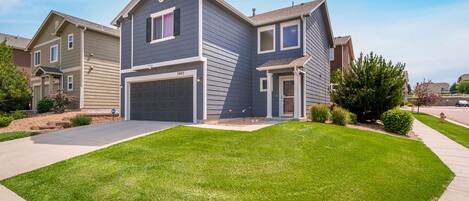 Frontal view of the house, corner lot with a small yard in a quiet neighborhood.