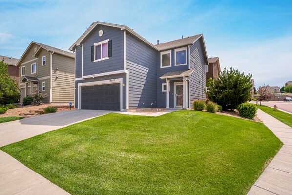 Frontal view of the house, corner lot with a small yard in a quiet neighborhood.