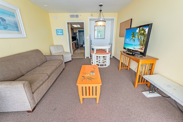 - Cozy and well-lit living space with a comfortable sofa and entertainment setup - Open layout connecting the living area to the dining and kitchen for convenience - Ideal for relaxing after a day at the beach or exploring local attractions