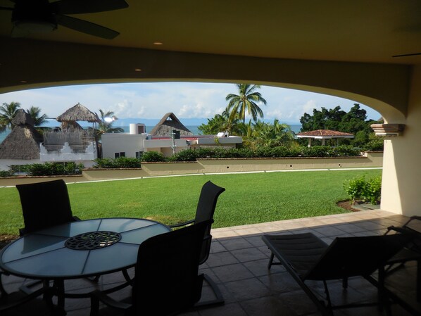 View from the living room looking through the outdoor patio toward the ocean.