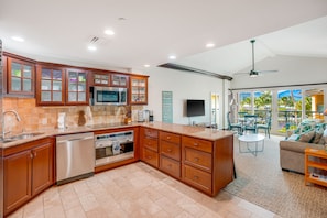 View from gourmet kitchen looking into living room with vaulted ceiling