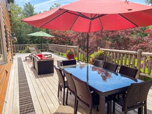 Enormous deck with 8 person table, sofa, and two chaise lounges.
