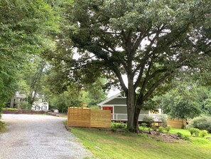 From main road – parking area to the right, yard partially fenced for privacy