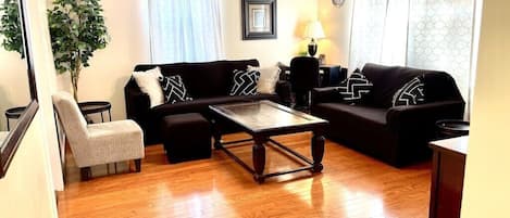 Living room with smart TV, desk & chair, puzzles, playing cards, & board games. 