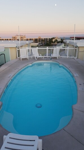 Rooftop pool with chairs and chaise loungers