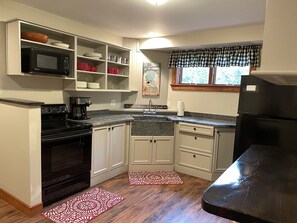 Kitchen with soap stone counters and apron sink.