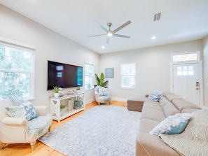 Inviting front room with plenty of seating and large smart TV