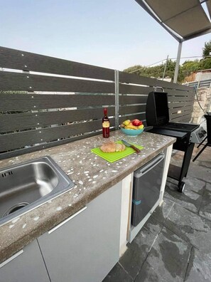 BBQ area with gas BBQ, mini fridge and sink. 