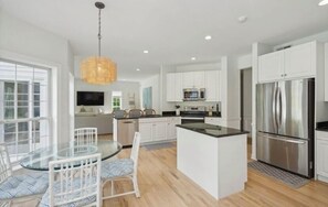 Open concept kitchen with breakfast table and new appliances