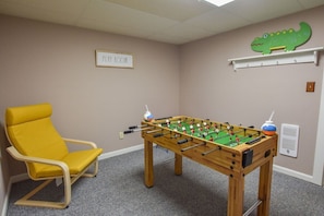 A game room in the finished basement has a foosball set.
