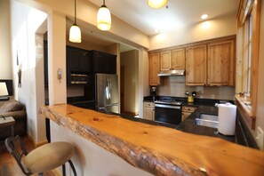 Well stocked kitchen with updated stainless steel appliances and coffee maker.