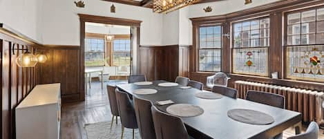 Formal dining room with Art Deco-inspired dining table for up to 10, open to solarium