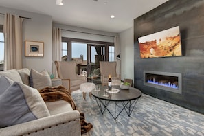 Living Room with plush contemporary furnishings, modern gas fireplace, Sony smart tv, and private balcony access
Note: New photos of living room chairs coming soon