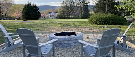 Stone fire pit with adirondack chairs. S’mores anyone?