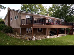 Backview of house w/ furnished upper fenced in deck area w/ access via sunroom

