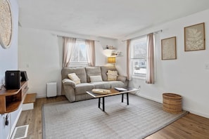 Comfortable living room with a gray couch, cozy lighting, and a smart TV