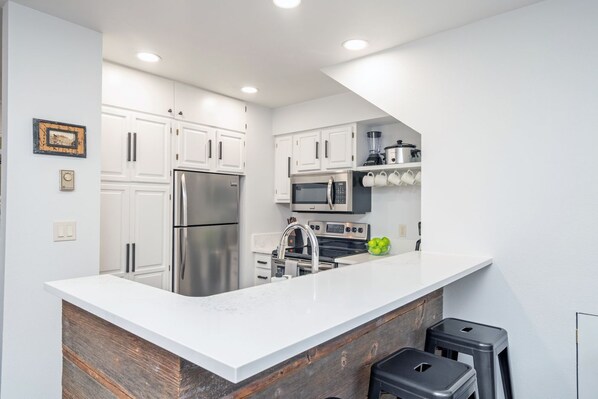 Updated kitchen with stainless steel appliances-electric oven, Refrigerator, microwave and dishwasher.