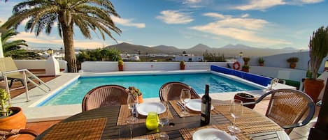 Terrasse mit Essbereich, Pool und traumhaftem Ausblick.