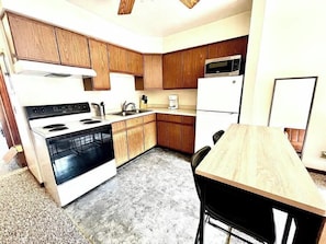 Kitchen with stove, refridgerator, sink, cabinets, countertop and dining table
