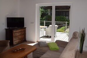 Wohnzimmer mit Couchlandschaft (Schlafcouchfunktion) und Terrassenzugang