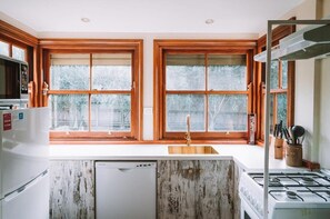While retaining its rustic charm, the kitchen is updated with contemporary brass tap ware, combining old-world style with modern convenience.
