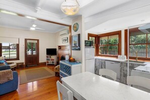 Timber floors throughout lead to the informal dining area, complete with a 1950’s Formica table and antique buffet. The renovated kitchen overlooks the beautiful olive trees and lawn from windows that attract sunshine from sunrise to sunset.