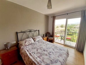 Double bedroom with fitted wardrobes and balcony with table and 2 chairs.