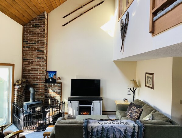 Bright living room with vaulted ceiling and skylights. 