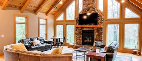 The giant great room features a huge stone fireplace with gas insert. A huge wall of windows overlooks the pond & patio doors open both the deck and the koi pond. A 70 inch smart tv and DVD is above the fireplace.
