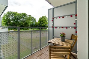 Spacious balcony with outdoor furniture. 