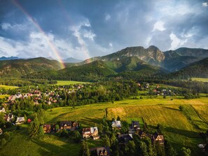 A stunning aerial view of the surrounding area, including lush green hills and a charming village nestled in the valley.
