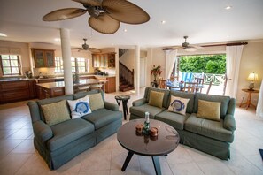 Open concept kitchen/living/dining area with TV and large balcony doors