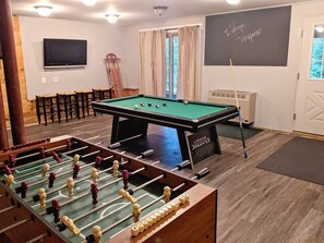 Our basement has been transformed into the ultimate play space including a pool table and foosball. Keep track of who's winning on the large chalkboard.