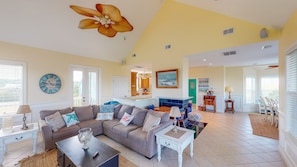 Comfortable seating area with huge smart TV and cathedral ceilings.