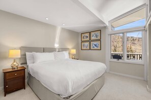 Vaulted ceilings, California King Bed, flat screen TV and numerous windows are featured in the bedroom of this vacation rental.