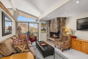The living area is very inviting with vaulted ceilings, a wood burning fireplace and comfortable furnishings.